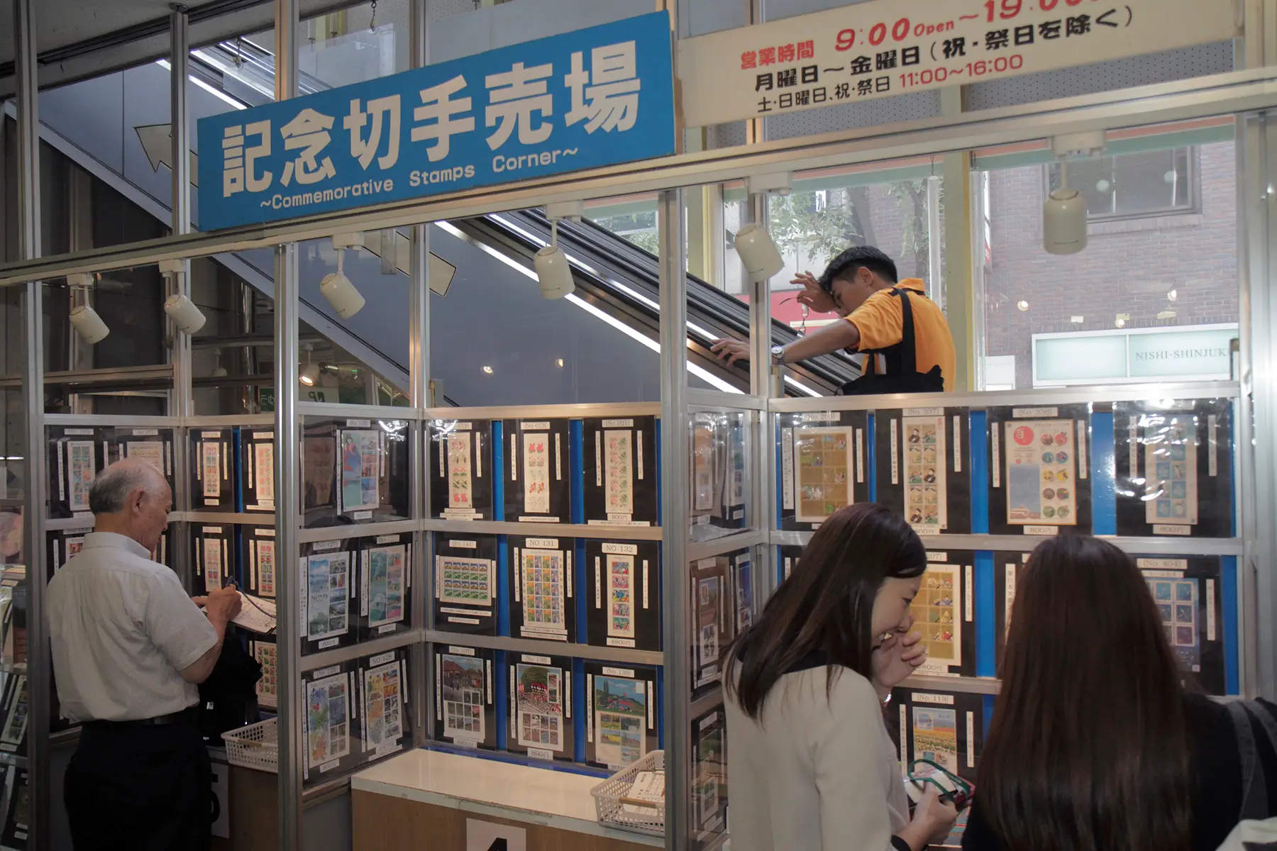 People looking at a display of commemorative stamps