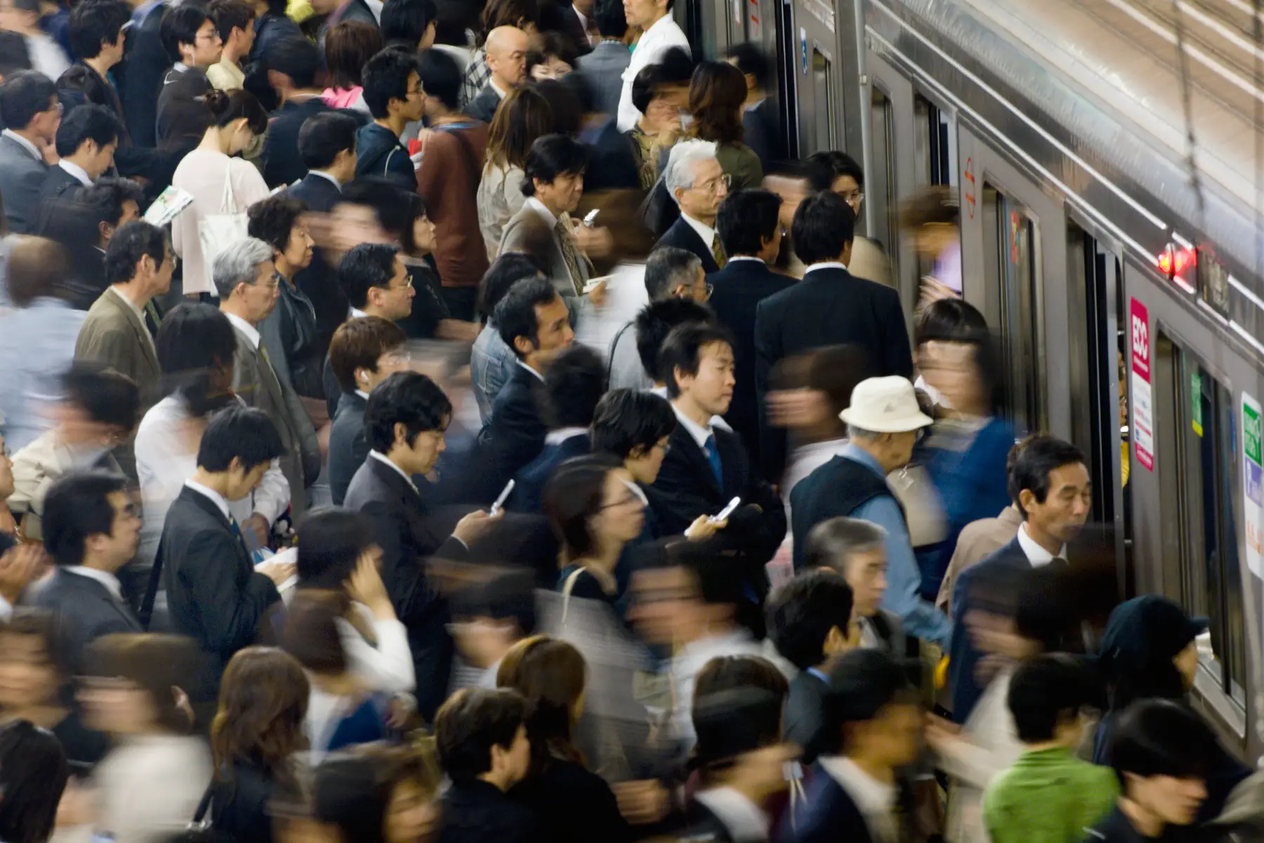 an aerial shot of hoards of commuters cramming onto a train at Umeda Subway Station in Osaka