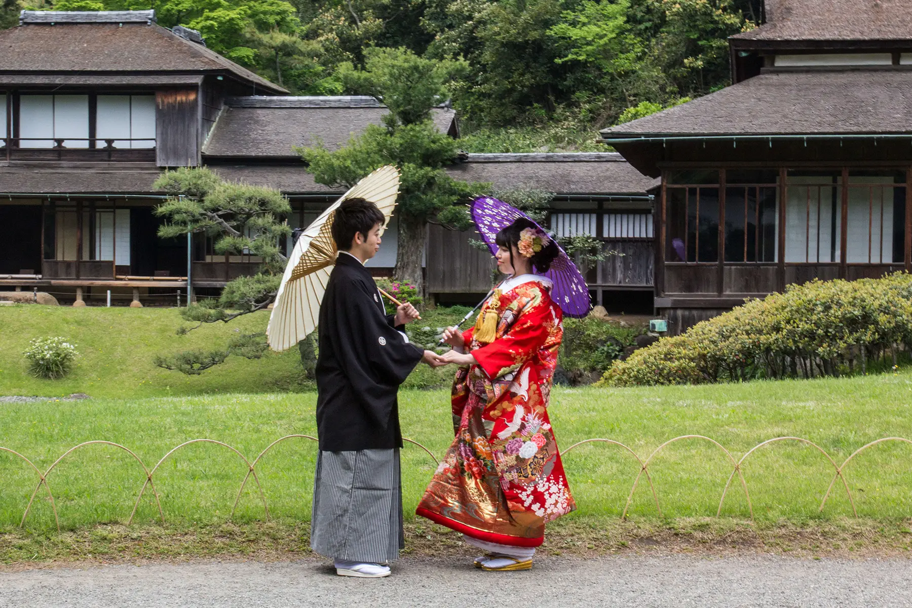 A couple in wedding clothing in the grounds of Yokohama gardens