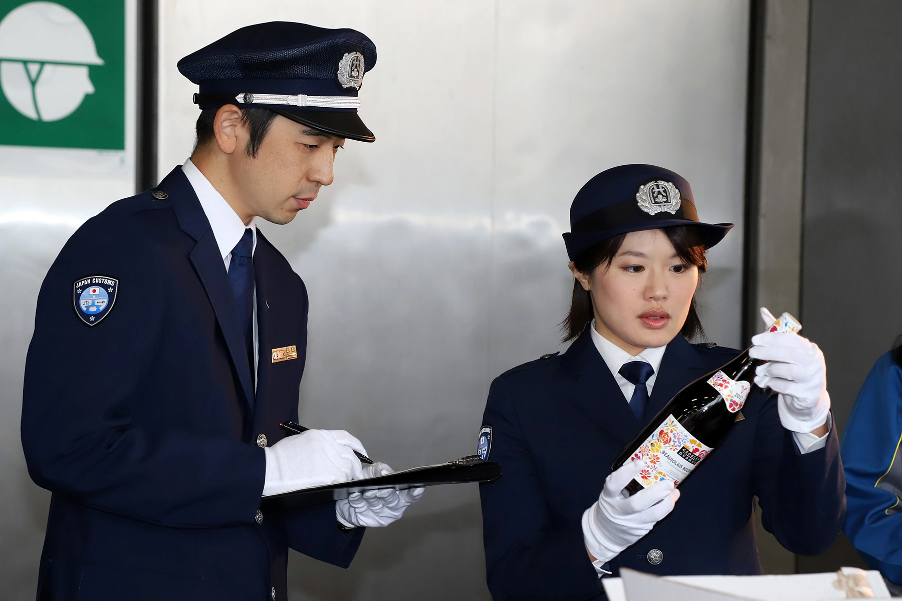 Japanese customs officers checking a bottle of wine