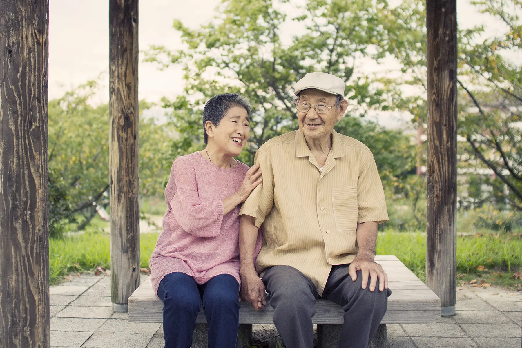 Elderly Japanese couple sitting on a park bench in Kyoto