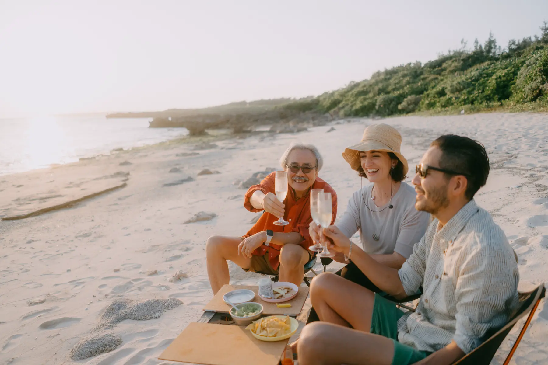 Family toasting during a beach picnic on Miyakojima Island, Okinawa