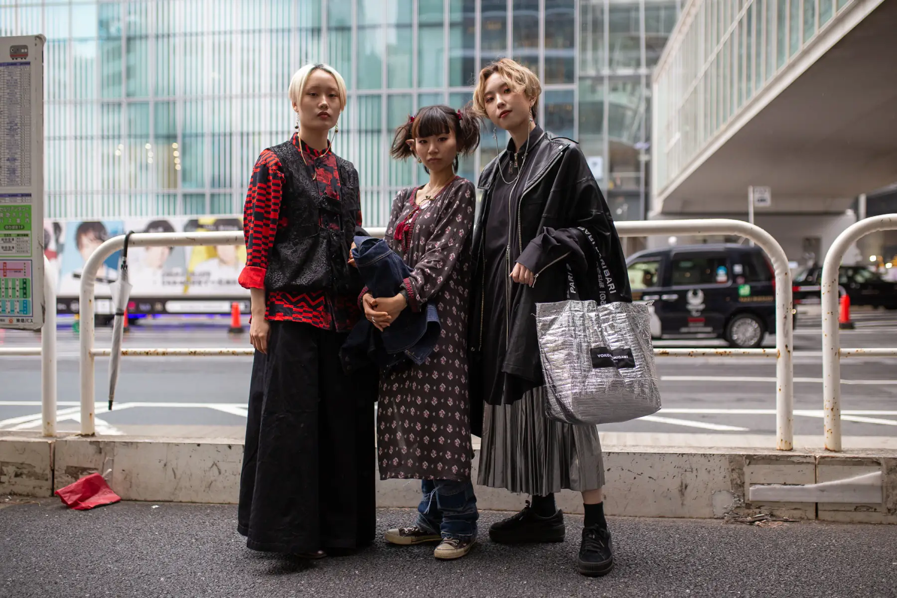 Three people in modern-day dress visit Rakuten Fashion Week in Tokyo