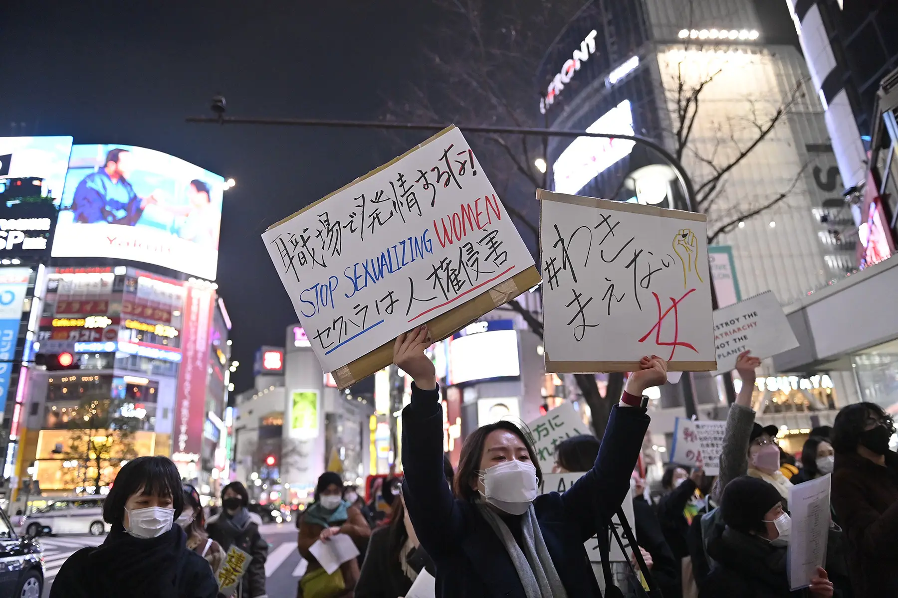 A Japanese woman holds a banner reading 
