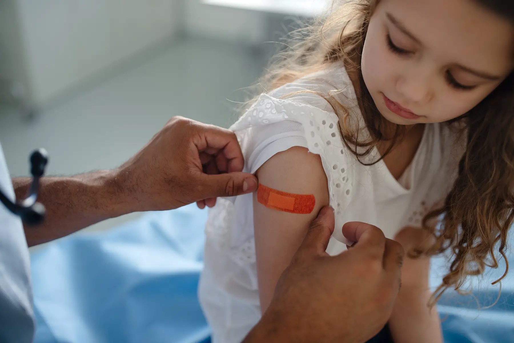 Doctor puts plaster on girl's arm
