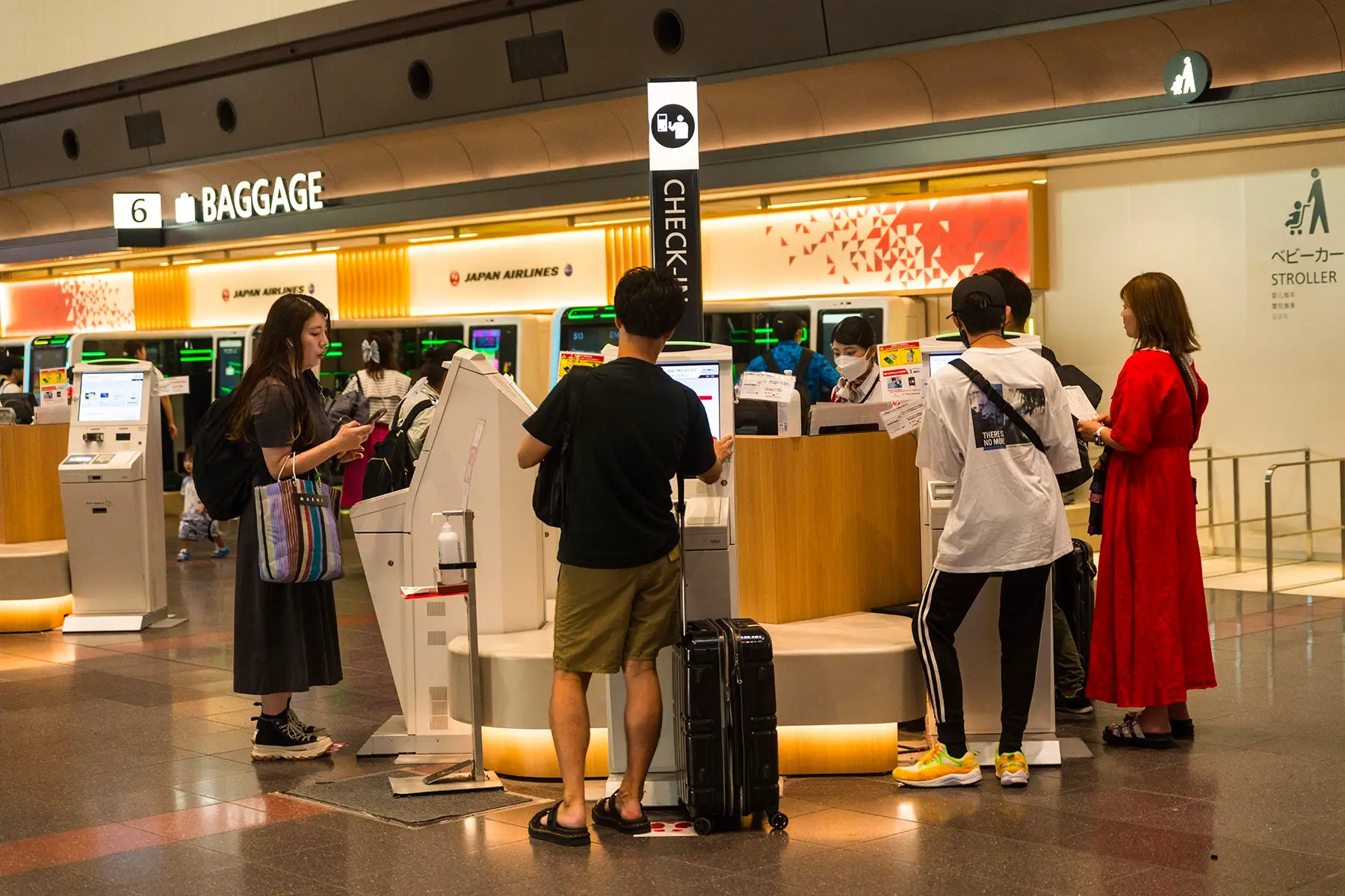 Passengers checking in at self-service machines at Haneda Airport in Tokyo