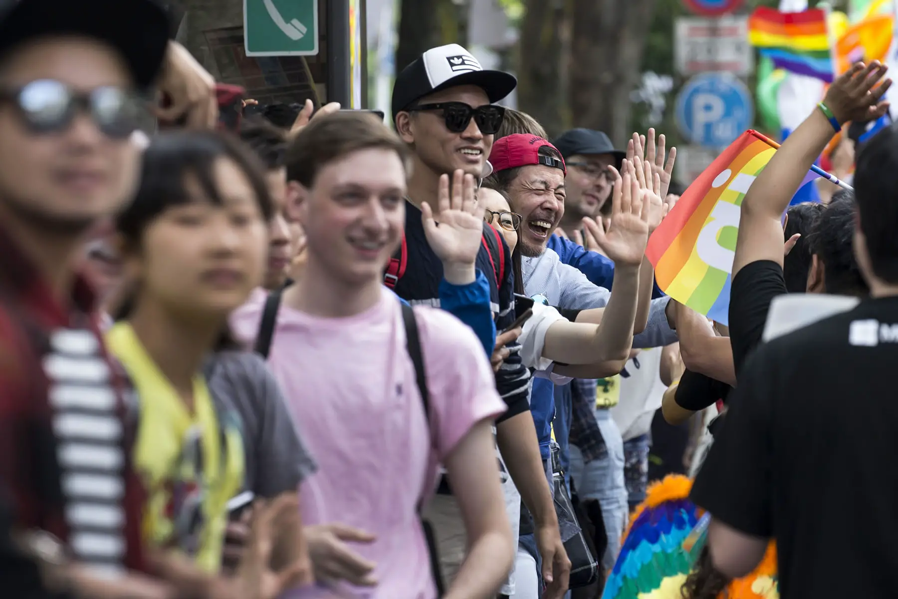A crowd is cheering as attendees high-five supporters during the 2018 Tokyo Rainbow Pride Parade in Tokyo, Japan. 