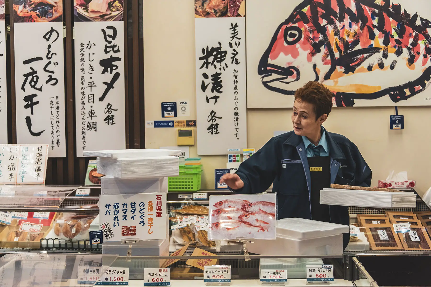 Fish lady standing by her stand at Omicho Market in Kanazawa, Japan.