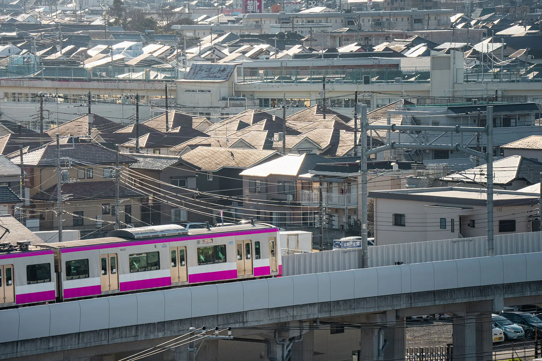 The pink Tokyo metro line riding through a residential area in Tokyo, Japan.