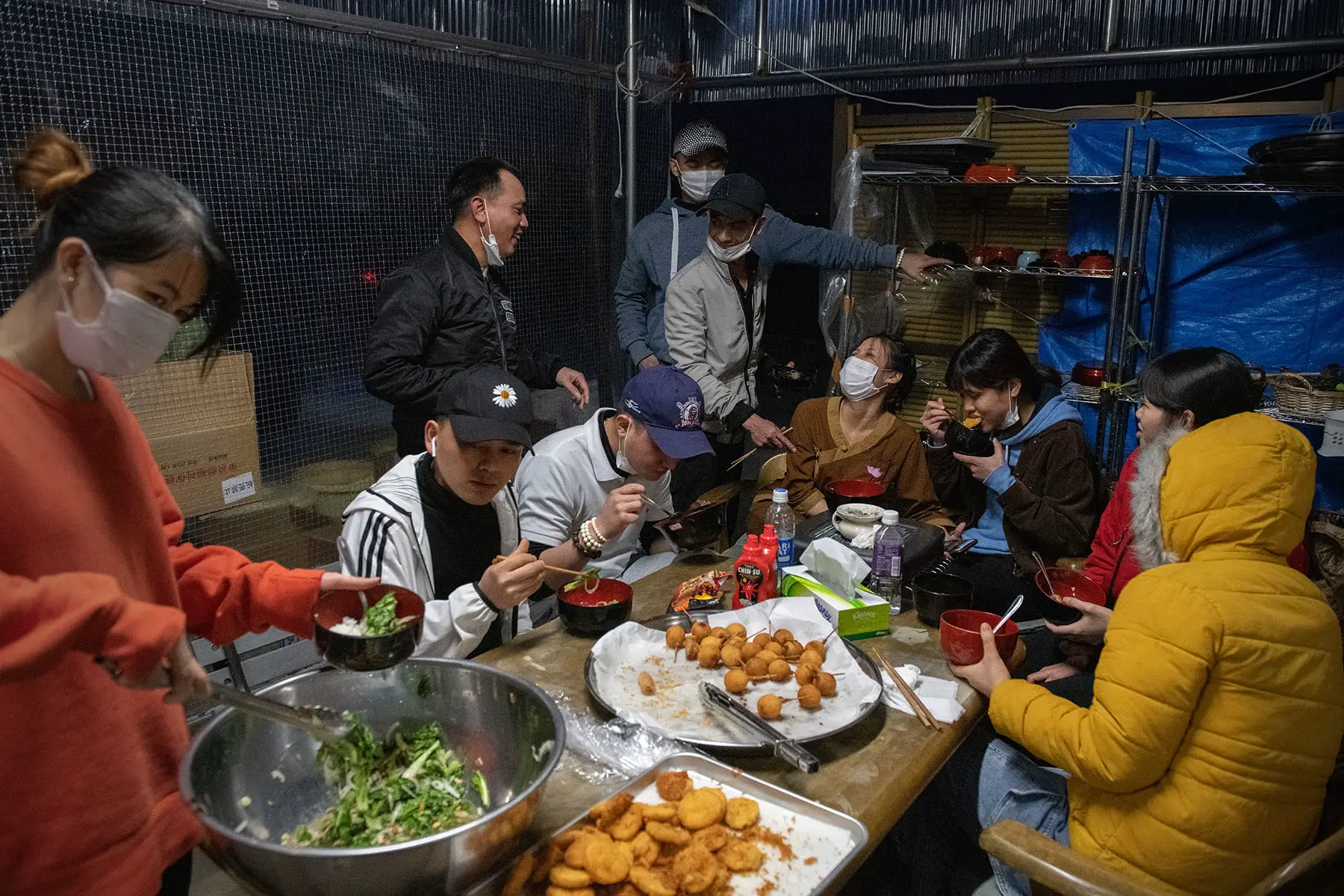 Vietnamese migrant workers made jobless and homeless by the coronavirus pandemic enjoy dinner together.