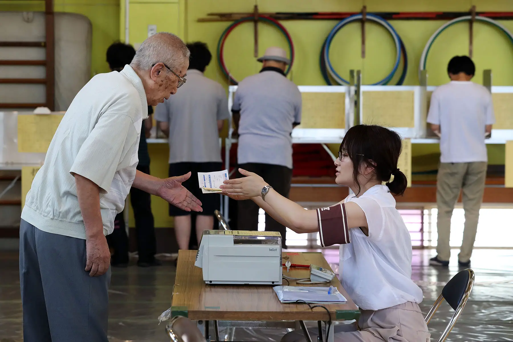 A voter receives a ballot paper in Japan's 2016 Upper House election at a polling station in Tokyo, Japan.