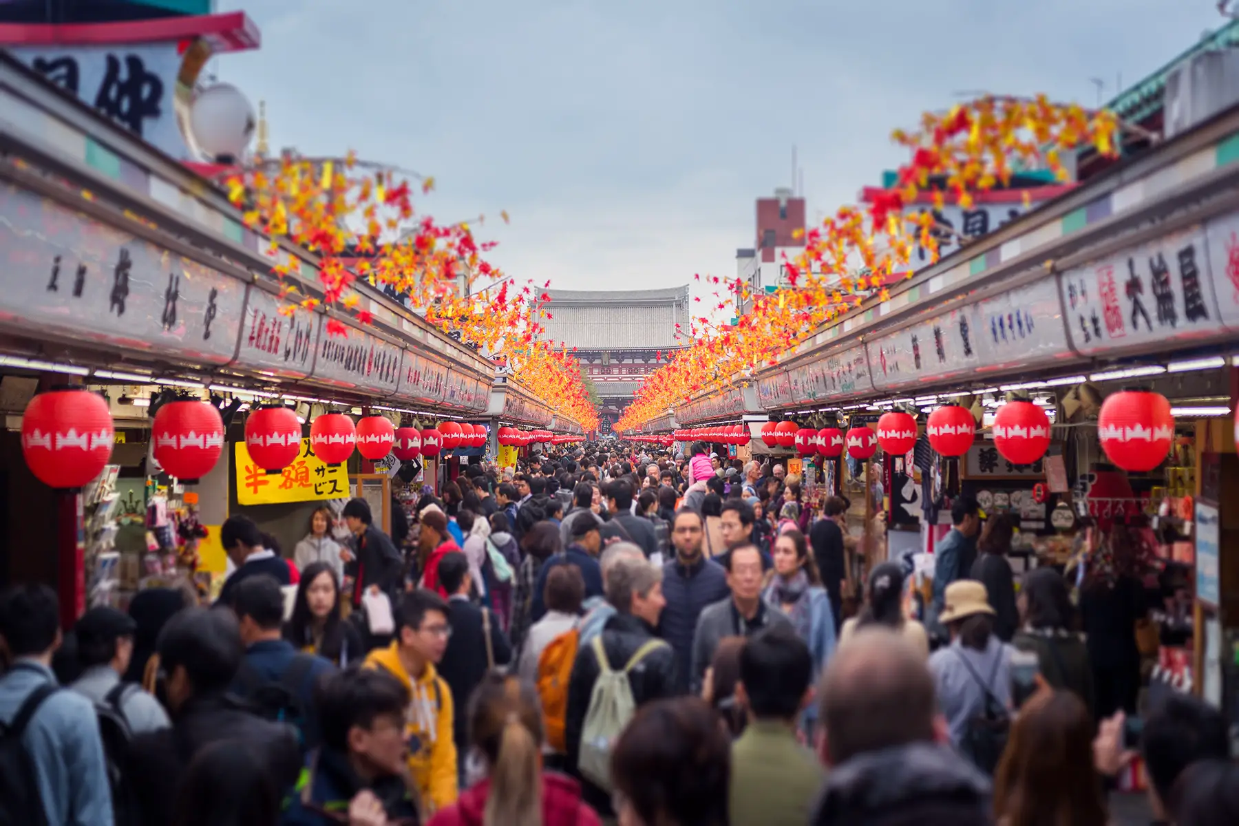 Crowds in Asakusa shopping street in Tokyo, Japan - red lanterns line the side of roofs