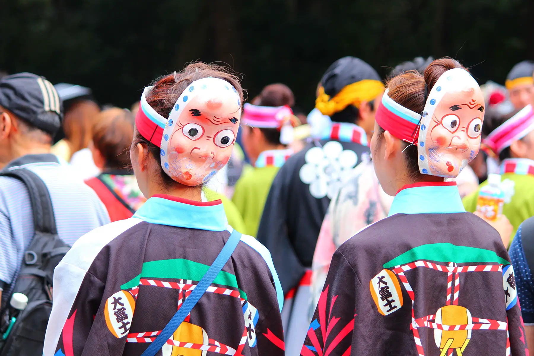 Crowd of people, tow walking with Japanese masks and festival dress, in Tokyo