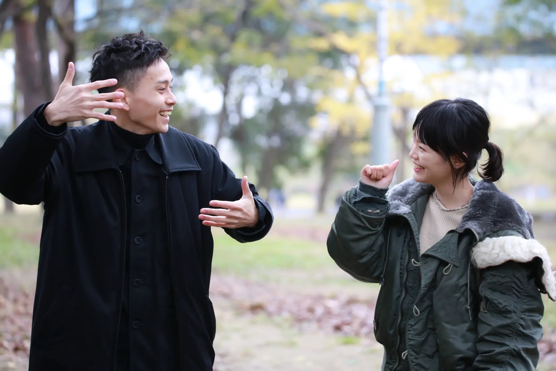 Smiling couple communicates in Japanese sign language