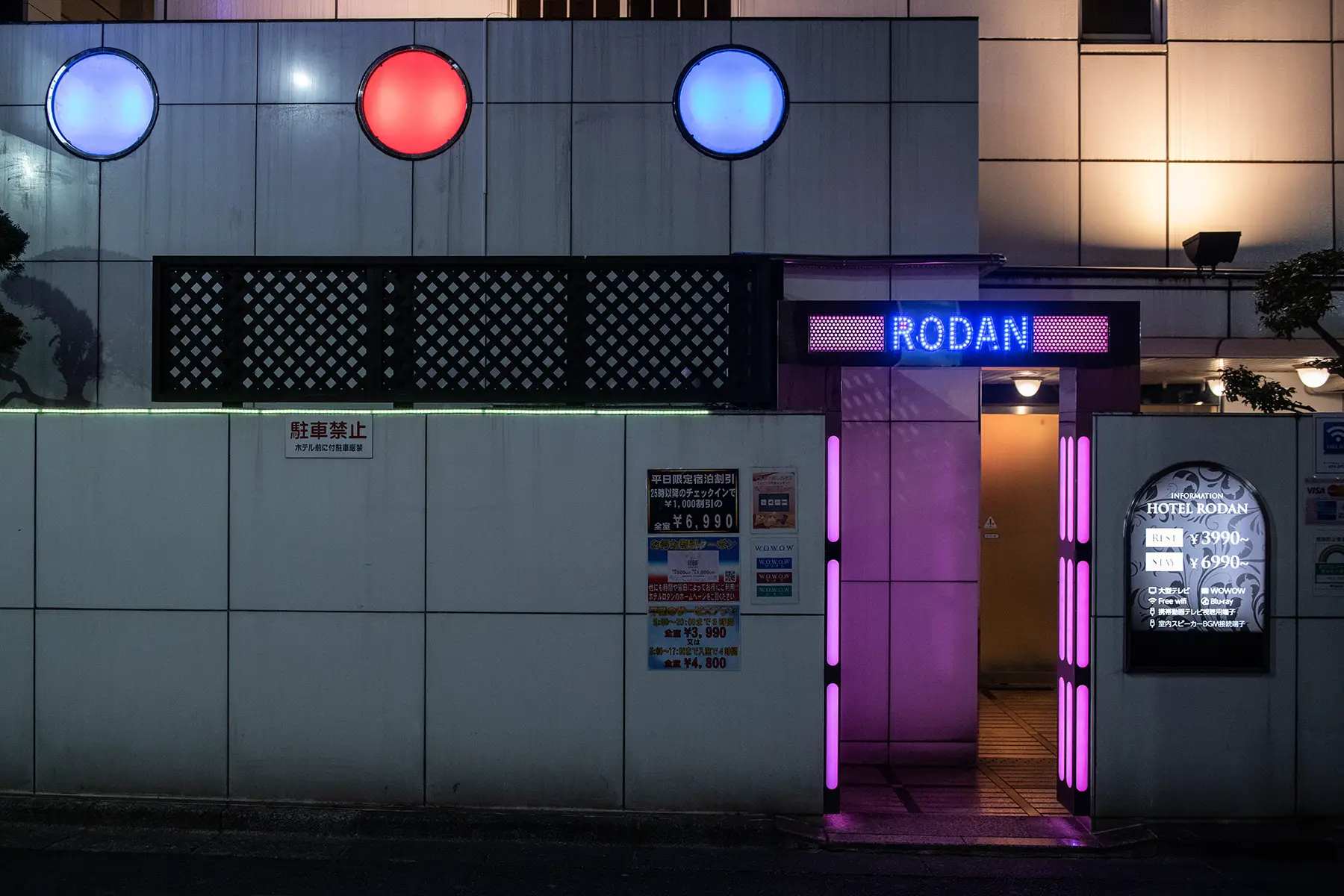 A dark building with red and blue neon lights