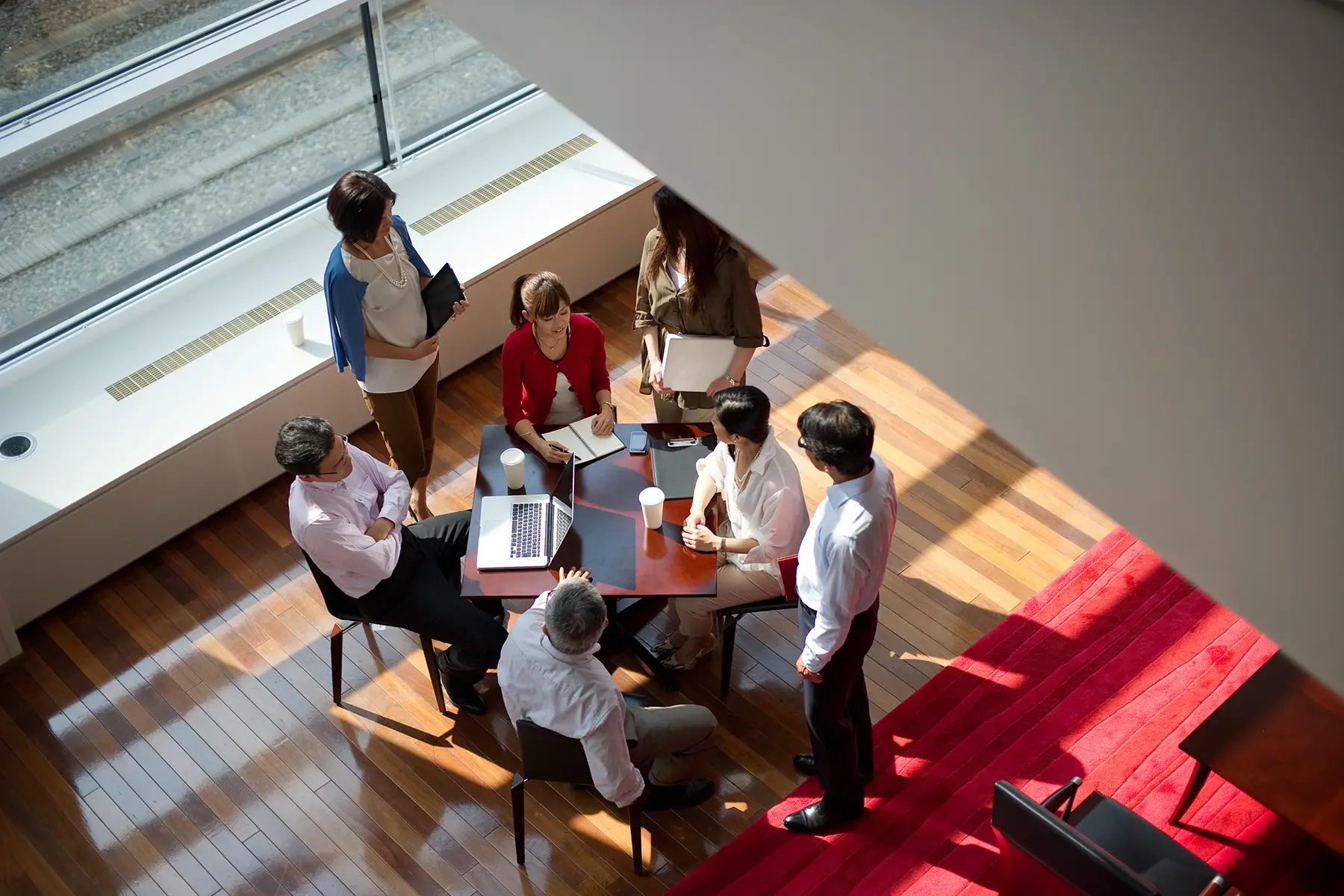 View of people sat around a table in an office from above