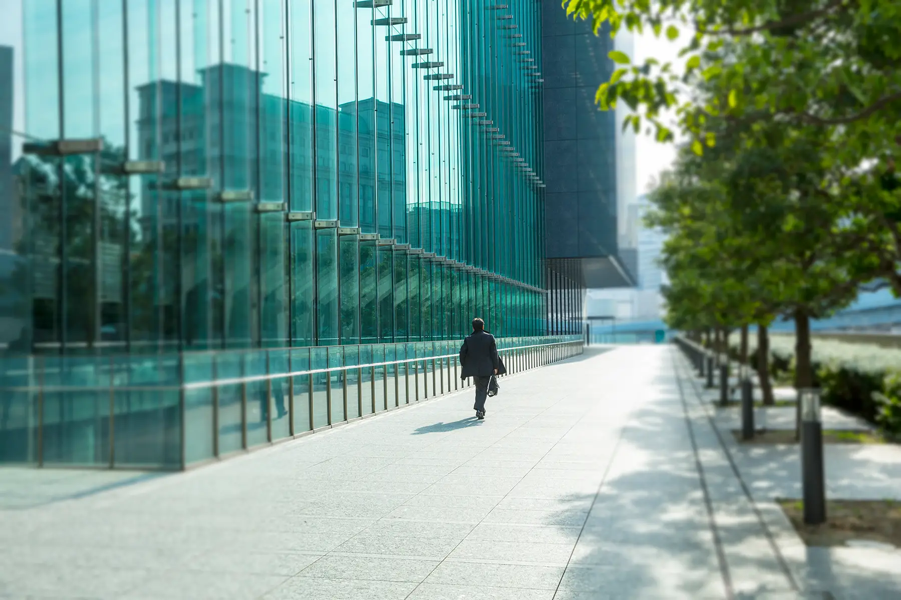 Person walking outside modern glass offices on a sunny day