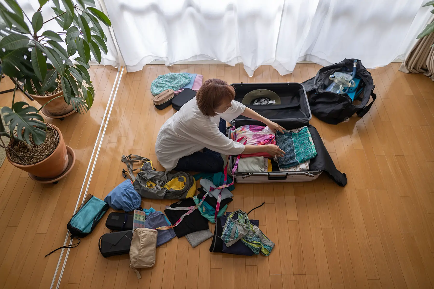 A woman packing her suitcase in a living room