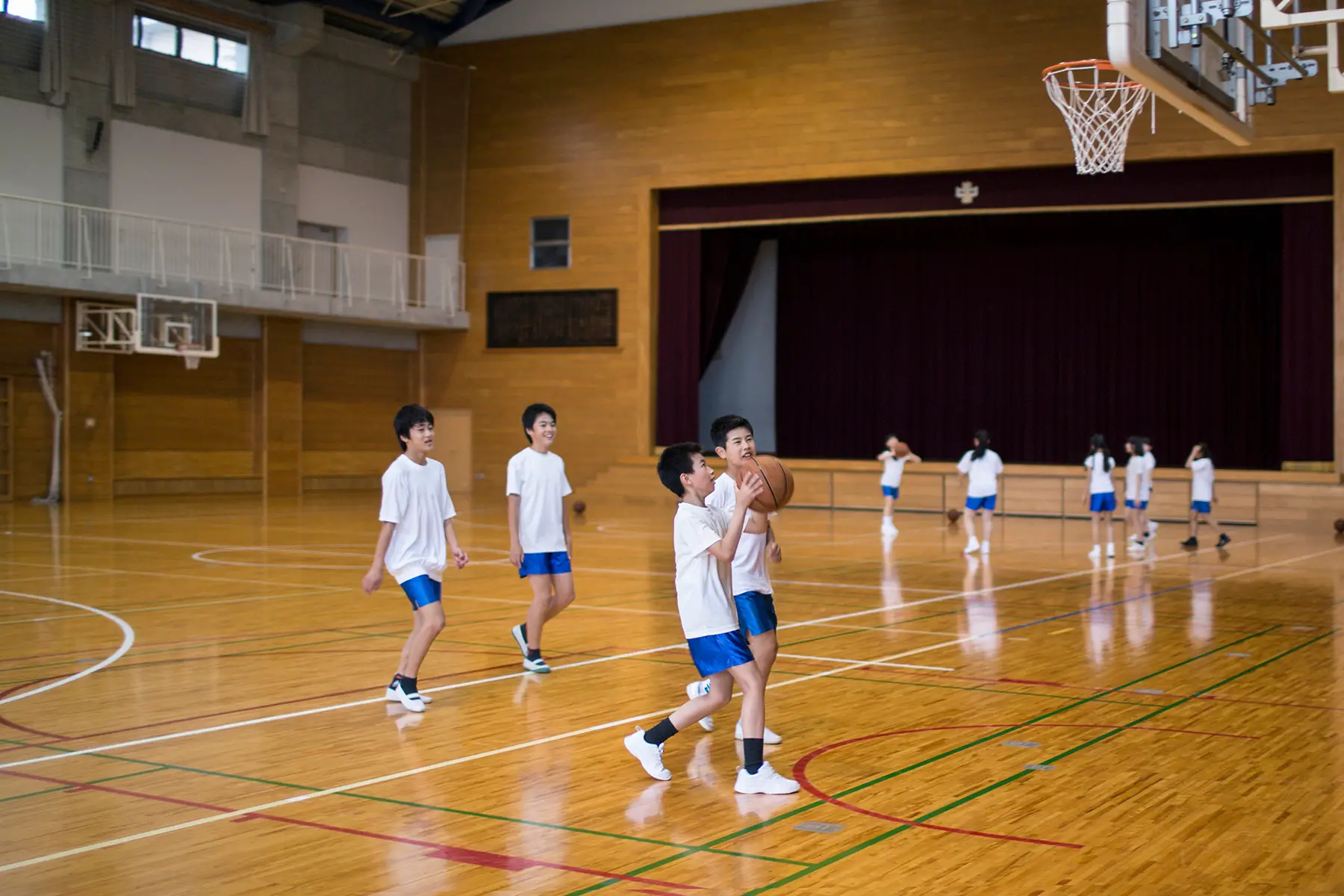Teenagers playing basketball in a gymnasium