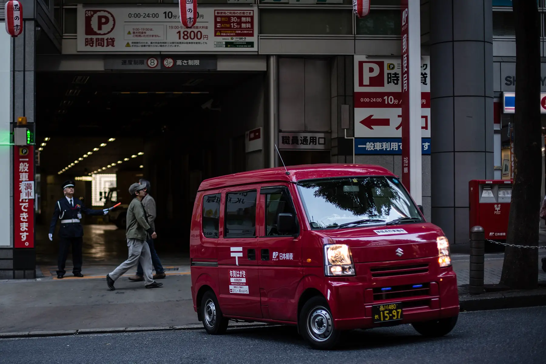 A red mail van leaving a post office center