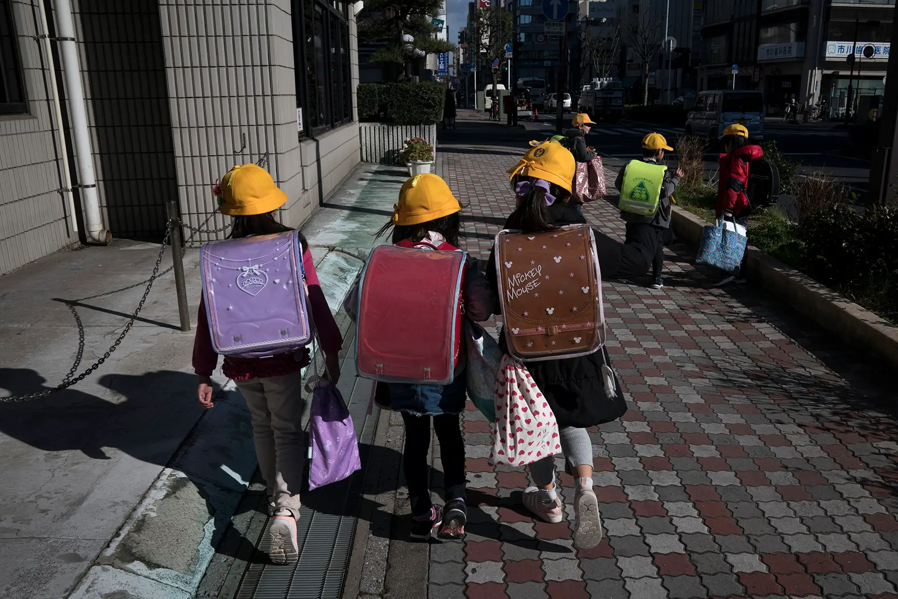 Primary school children with big backpacks walking to school