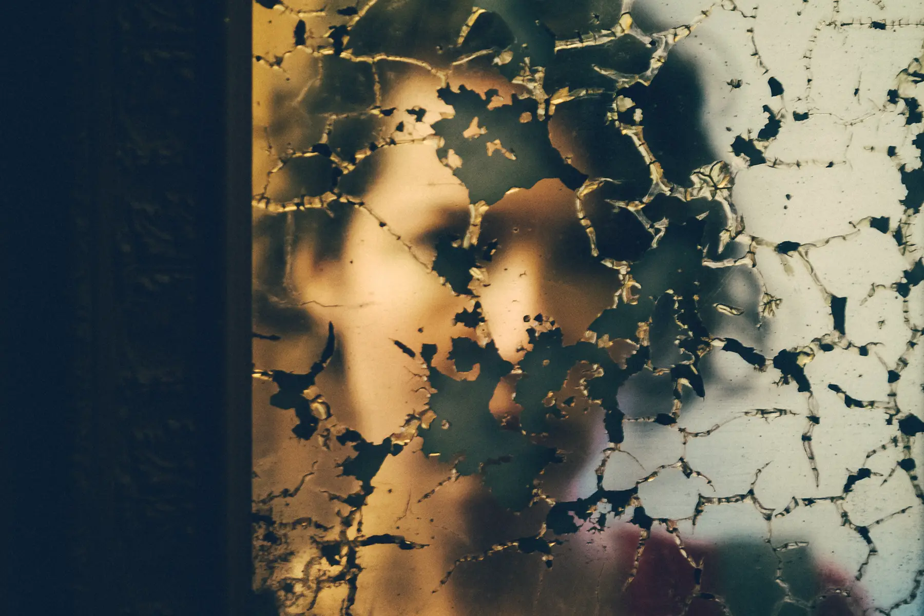 Women's reflection in a damaged mirror