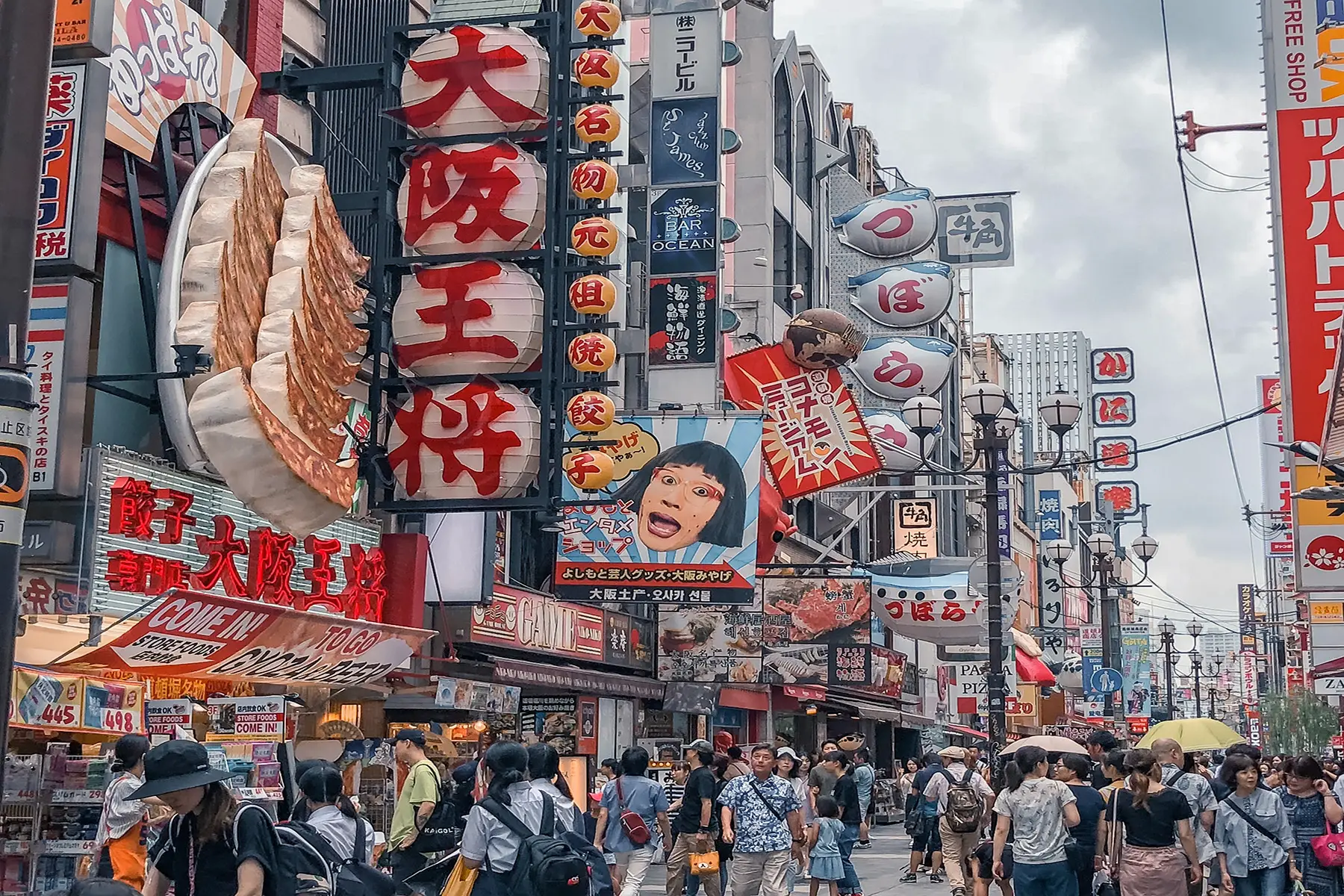 A busy street scene in Japan with many colorful sign boards and people