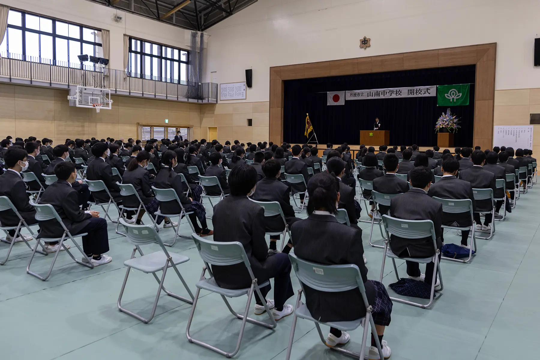 Students sitting in rows in an assembly hall facing the stage
