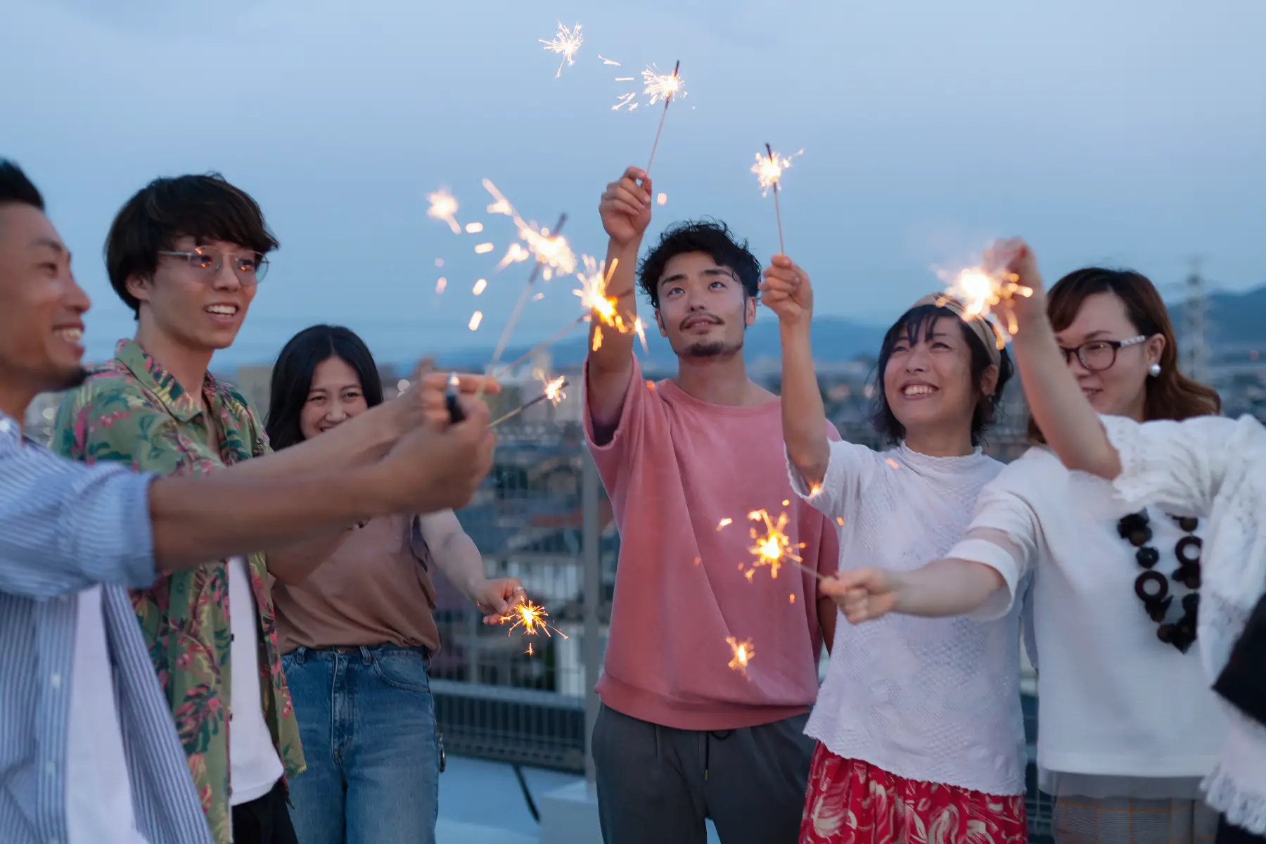 Group of six young adults holding sparklers and smiling