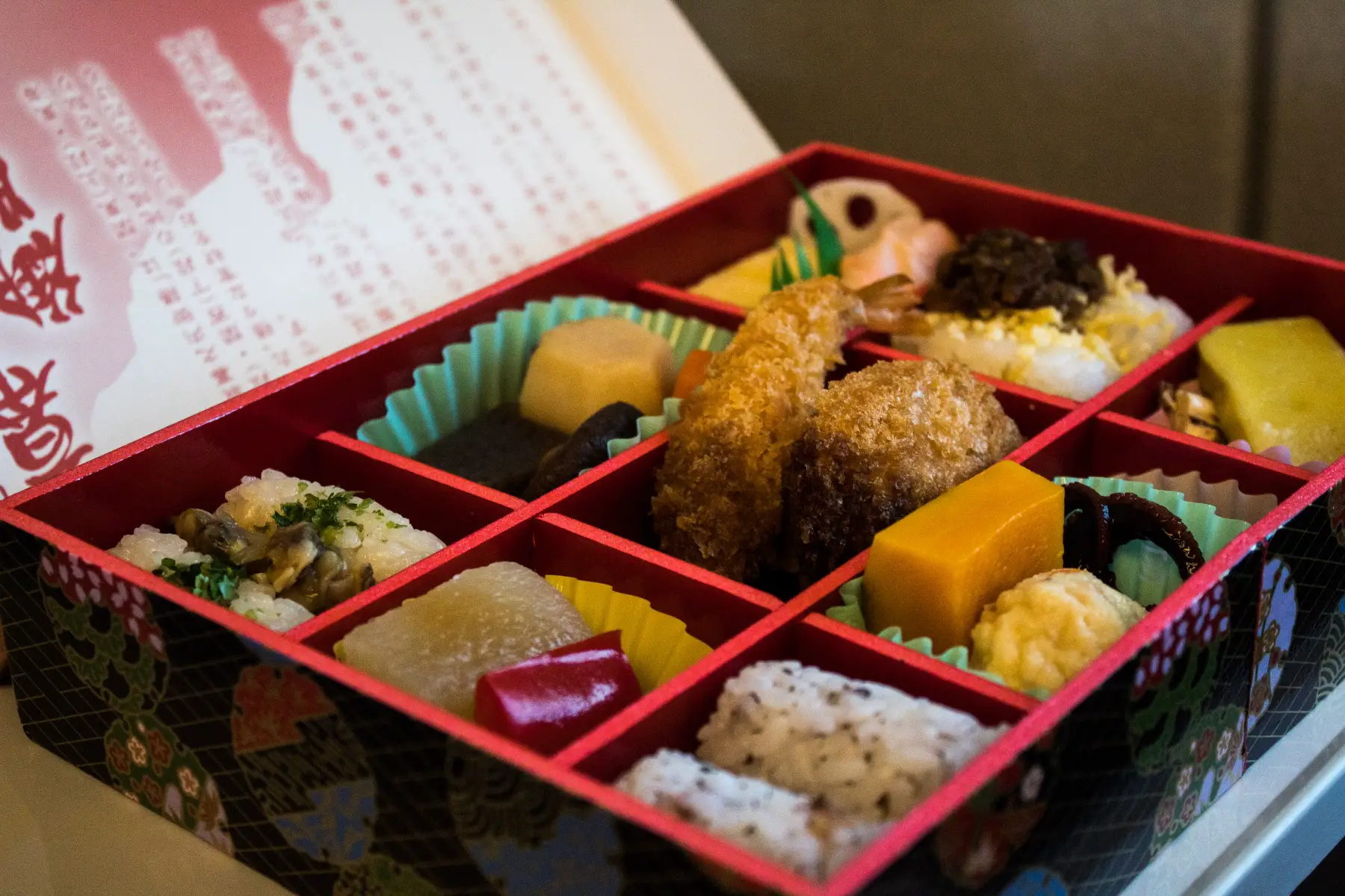 a close up shot of a Bento box full of colorful sushi served on the Shinkansen bullet train