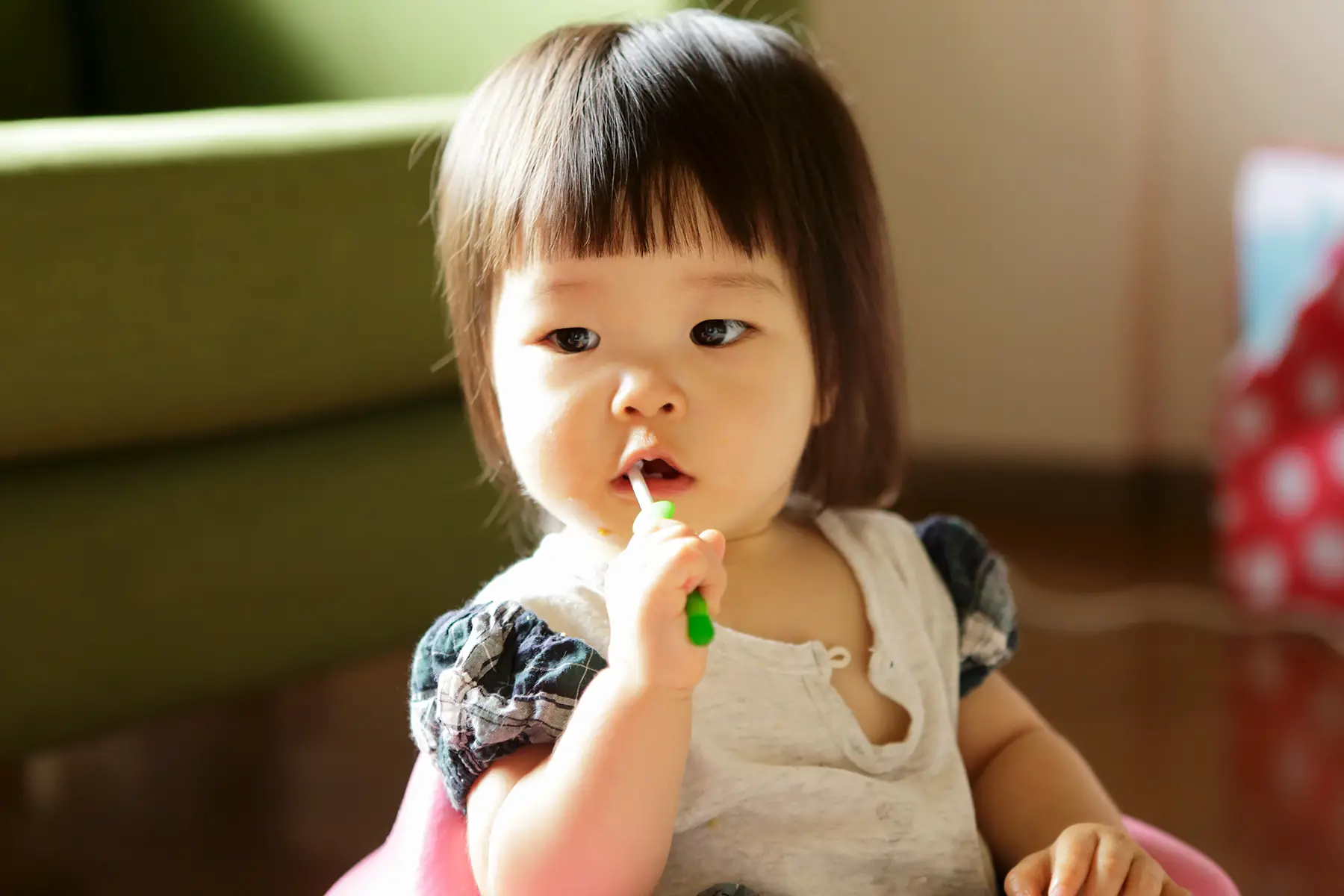A toddler brushing their own teeth