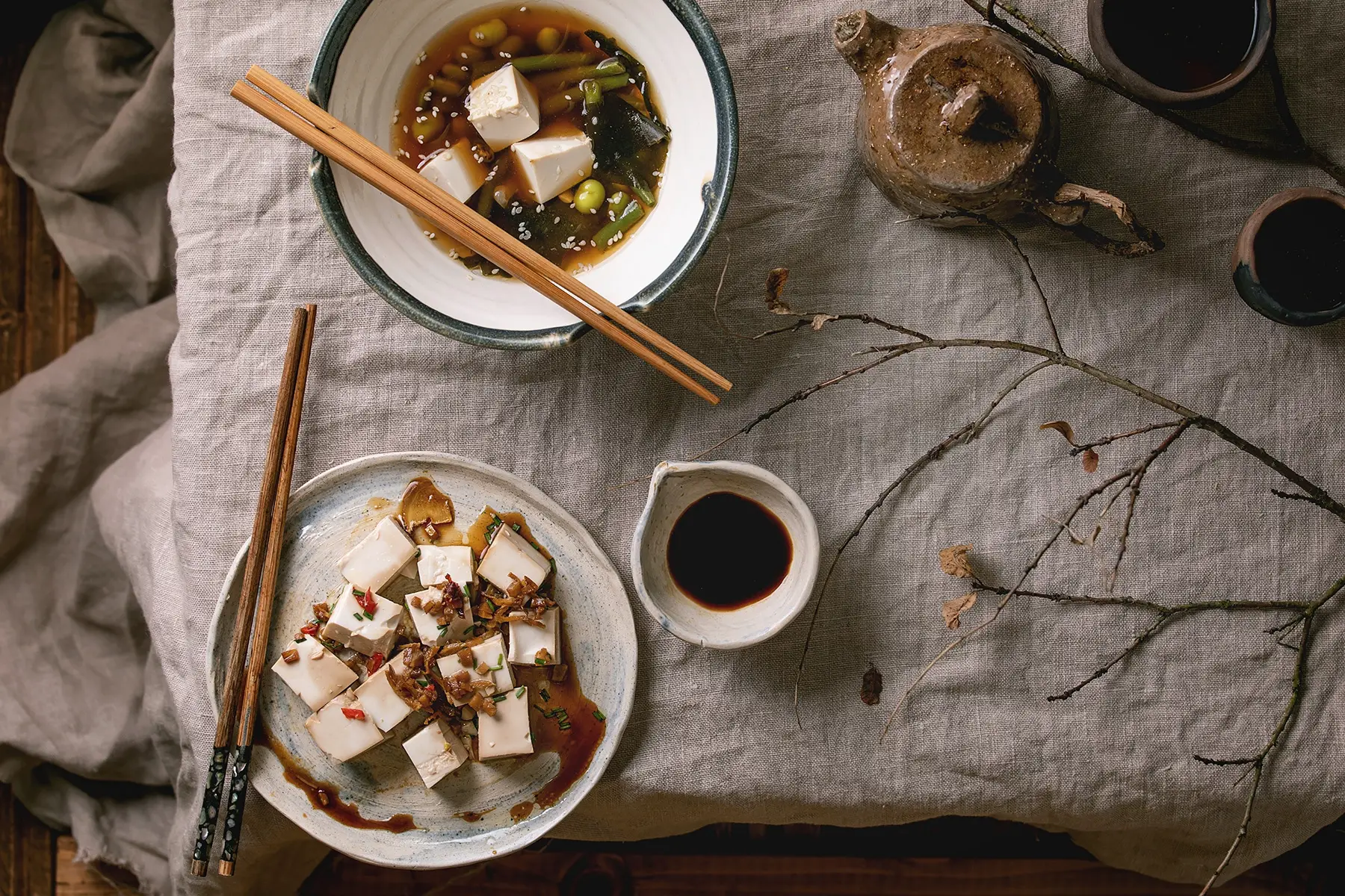 Two tofu dishes and a portion of soy sauce