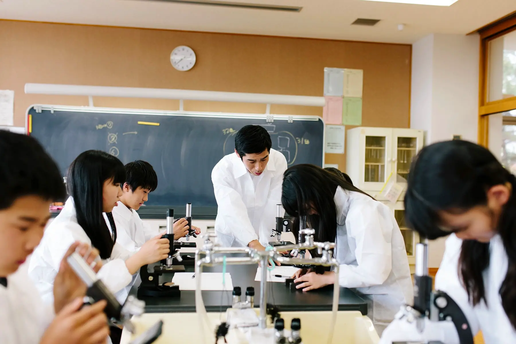 Science students using microscopes at university