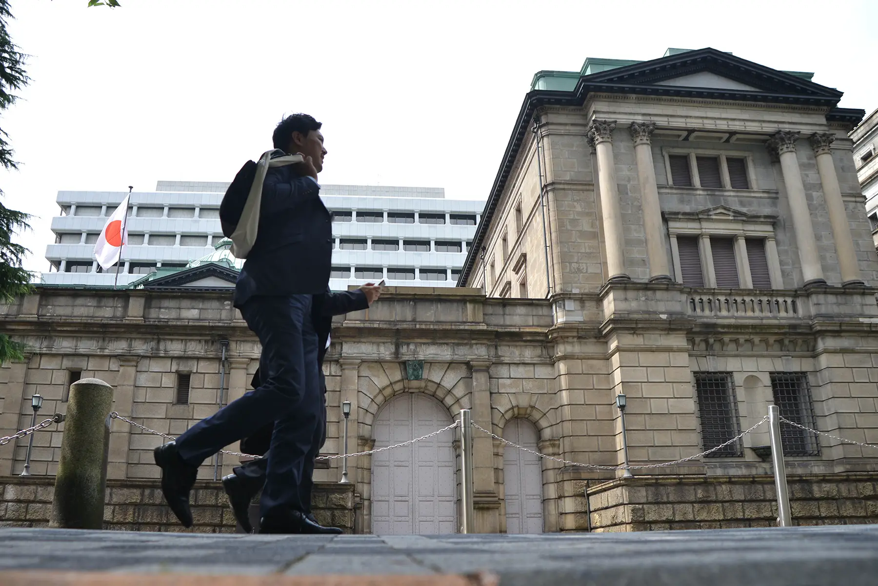 Businesspeople walking in front of the Bank of Japan