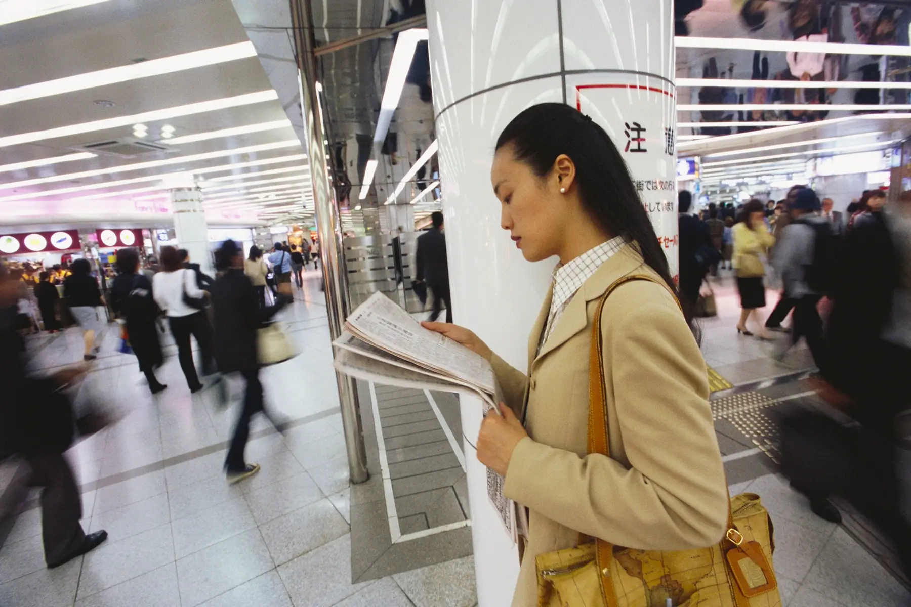 Woman reading a newspaper in Osaka Station