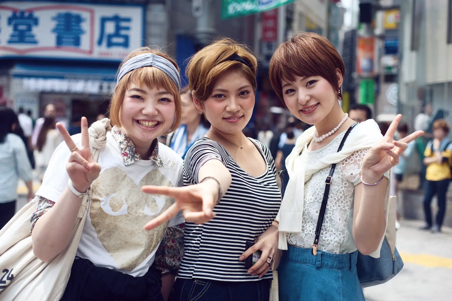 Three Japanese women in Tokyo making the V sign with their hands