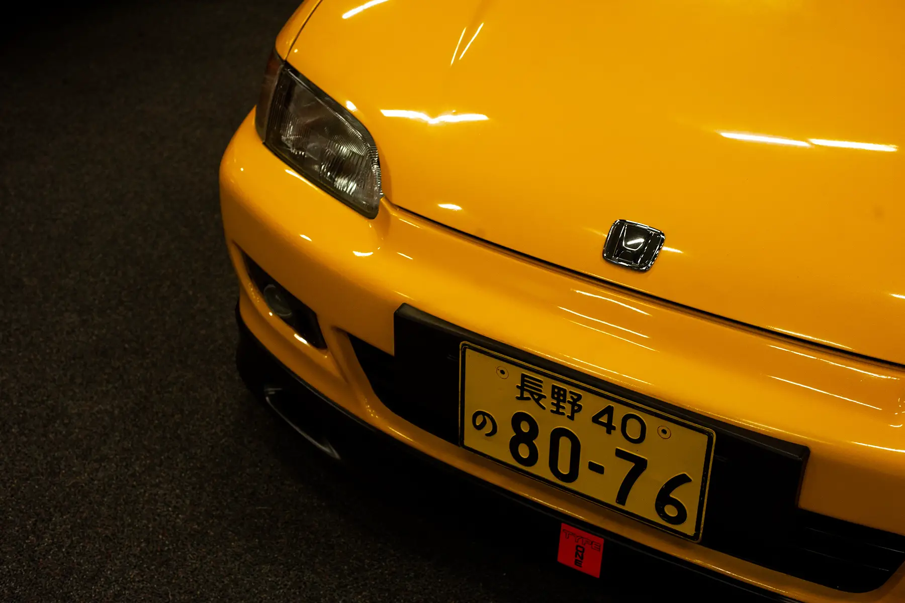 Close-up of a yellow Honda with a Japanese license plate