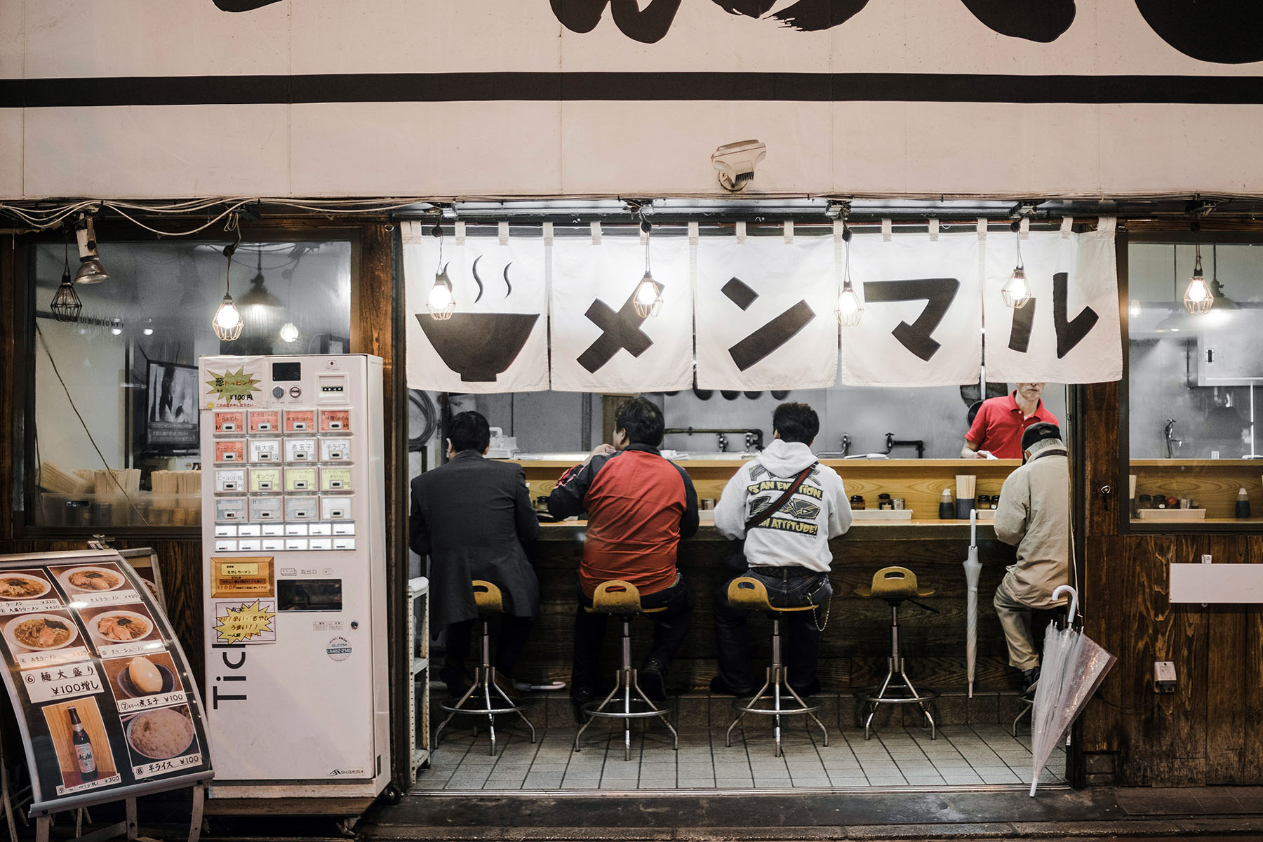 Four people sitting at the counter of a ramen restaurant in Taito, Japan.