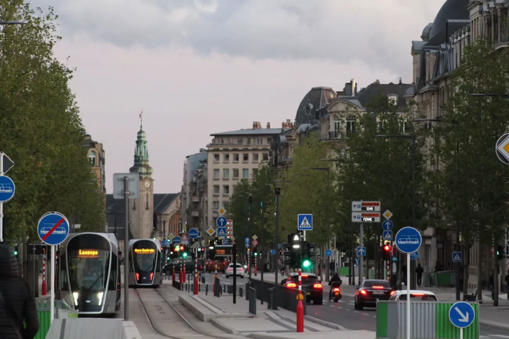 Busy road with cars and trams in Luxembourg city.
