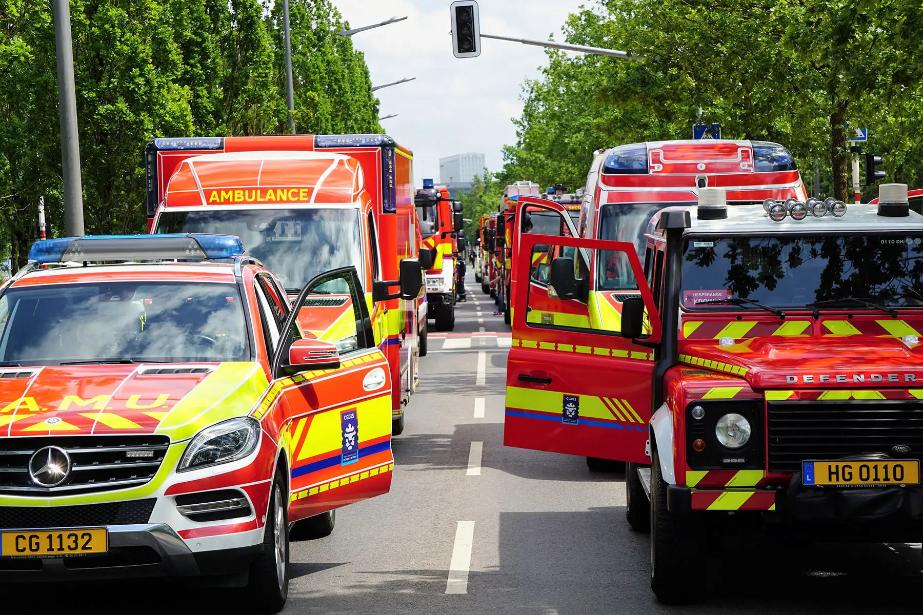 A fleet of ambulances are parked side-by-side down a street in Luxembourg