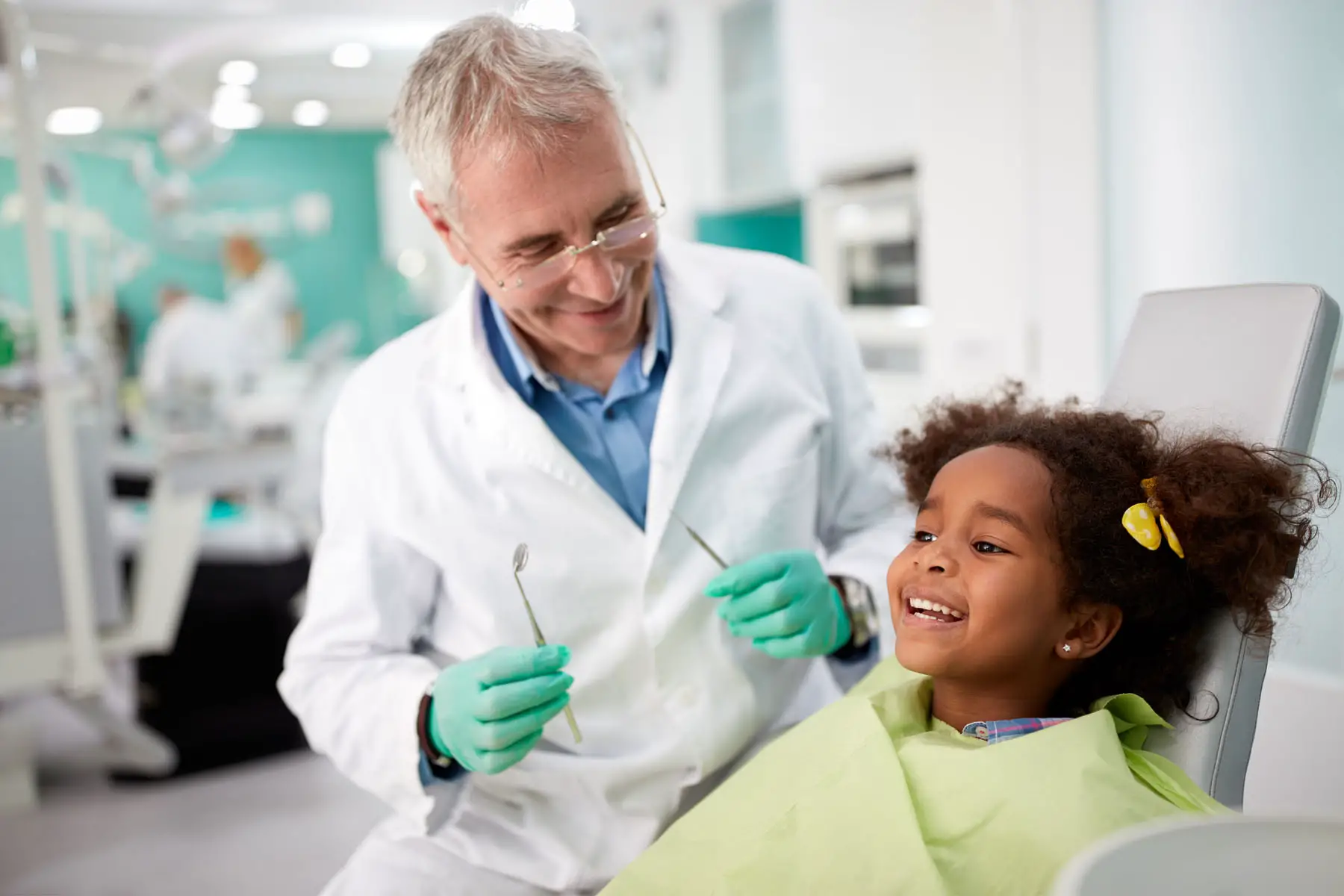 A dentist examines a child