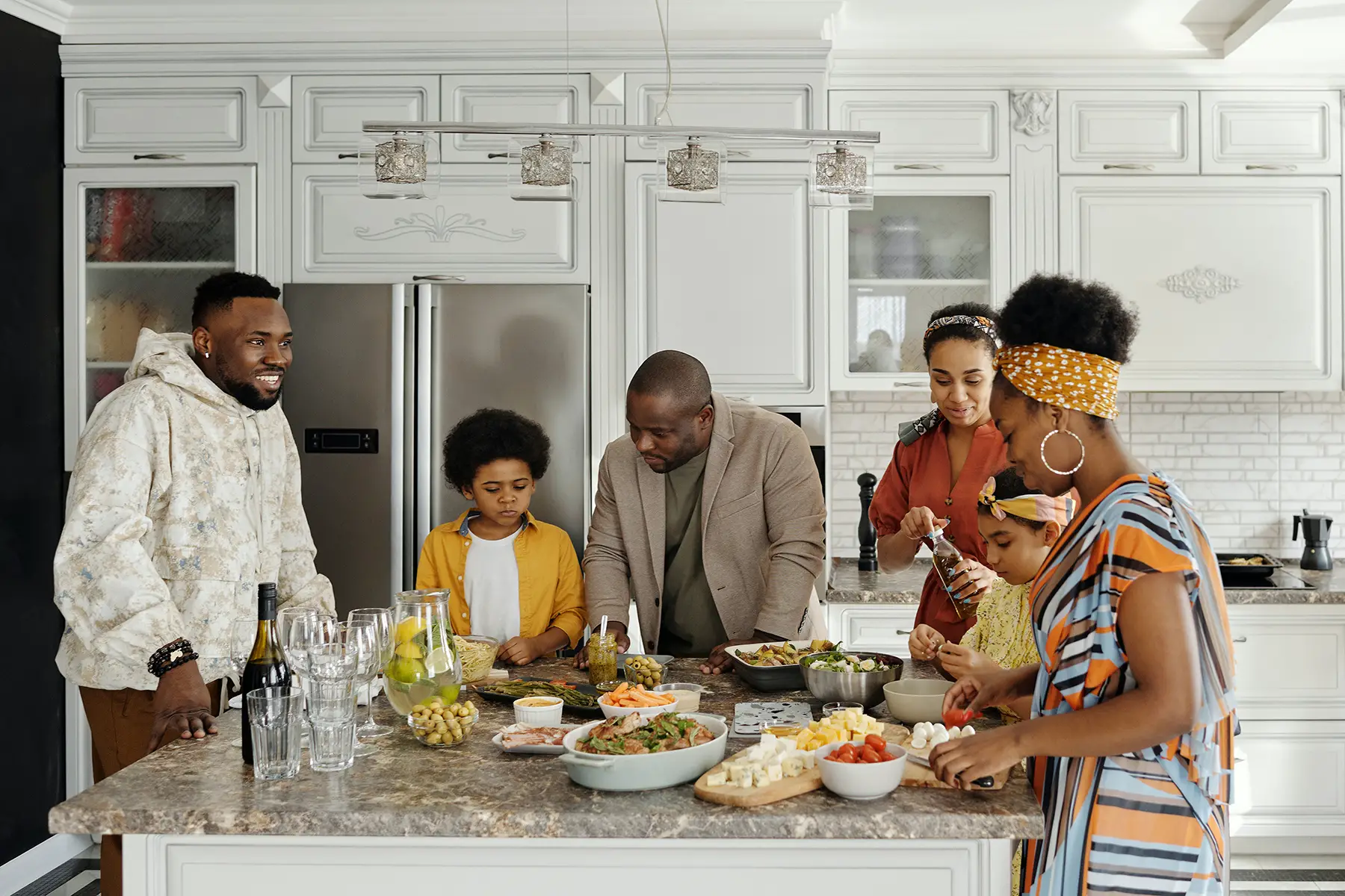 A family gathers around a kitchen island sharing food
