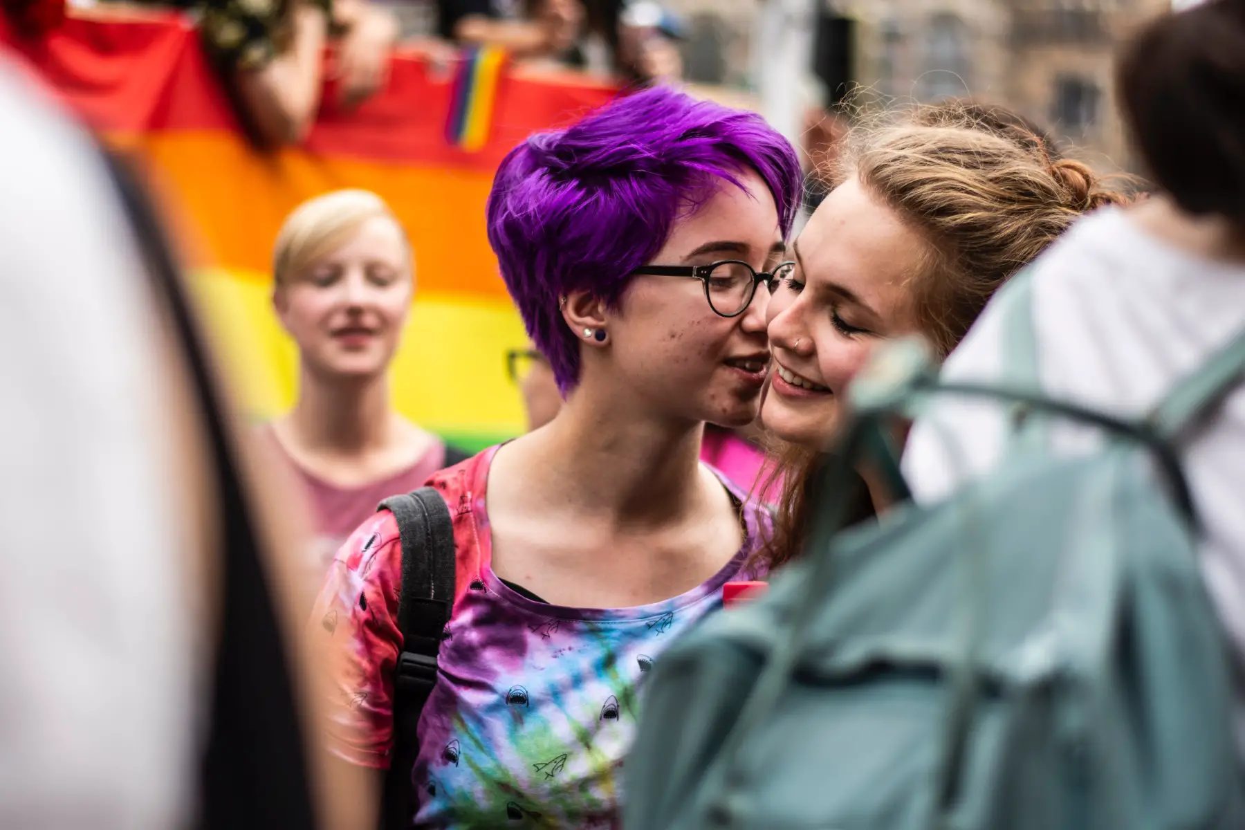 a close-up shot of a female same-sex couple affectionately cuddling during Pride festival
