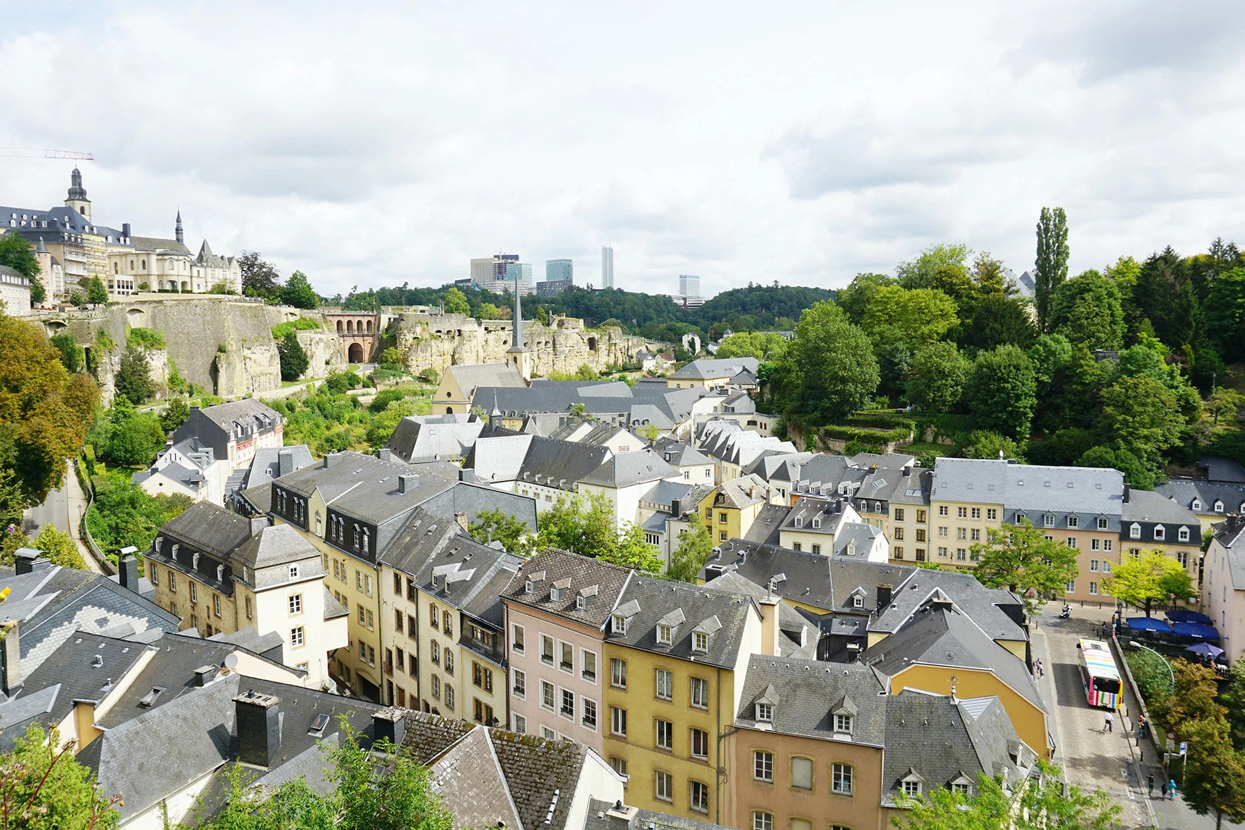 A view of Luxembourg City from above, showing houses in pastel colors and their roofs 