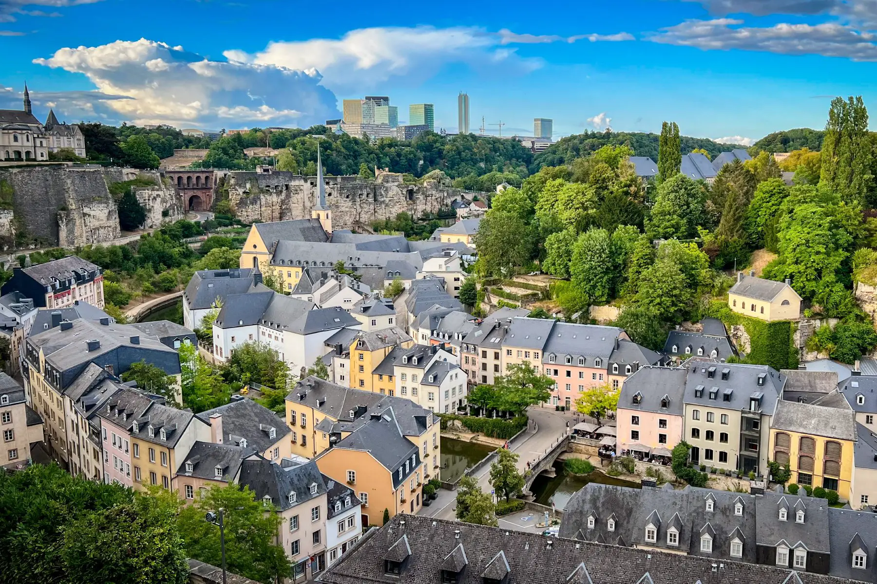 a landscape view of the Grund (lower city) quarter of Luxembourg City with rooftops in the background