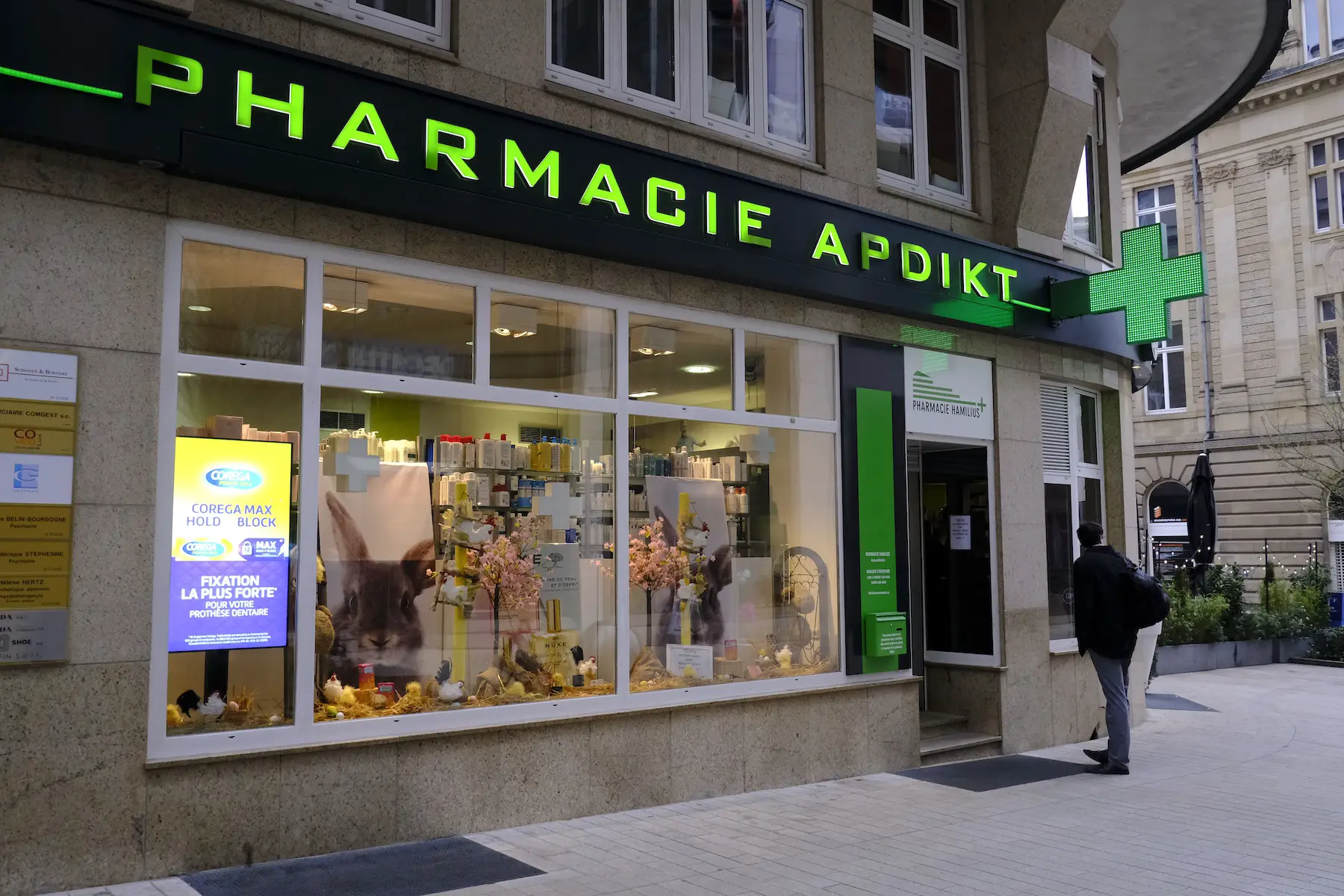 The entrance of a pharmacy in Luxembourg with a customer walking inside