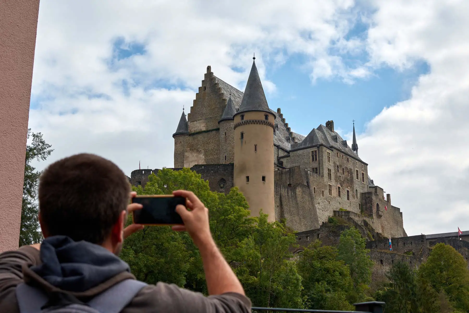 a man taking a photo of a castle in Luxembourg