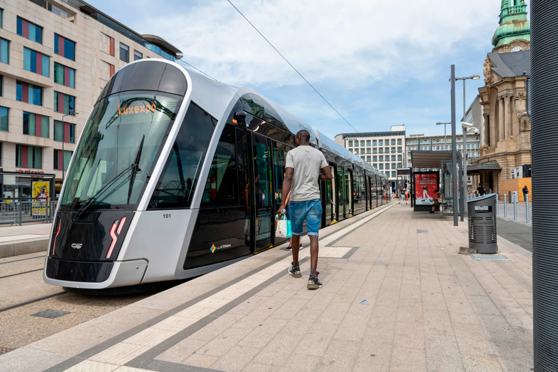 A man getting on a modern tram to Luxexpo, Luxembourg