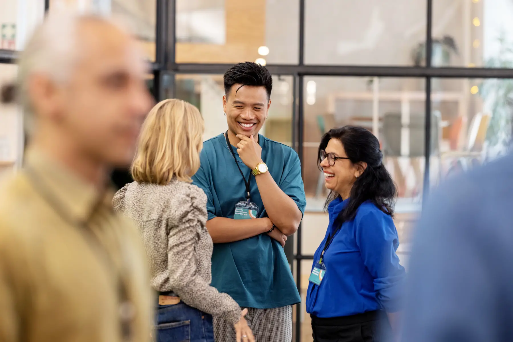 three multiracial business people chatting and smiling at a networking event