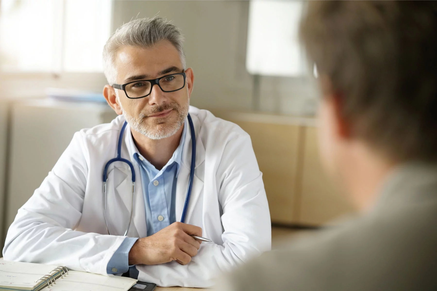 physician listens to a visiting patient